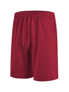Detail of red men's shorts showing herringbone jacquard fabric and drawstring waist