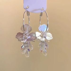 Détail macro de boucles d'oreilles fleur en cristal avec texture en métal argenté poli