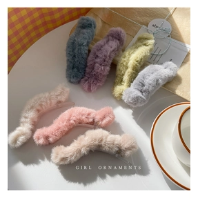 Detailed group shot of plush faux fur banana hair clips in various Morandi colors