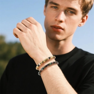Detail of natural agate and magnetic stone beaded bracelet on male wrist in nature