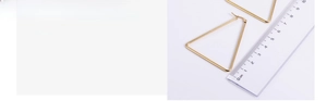 Detail view of large gold triangular geometric earrings measuring 5cm in size