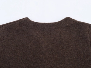 Detailed view of the round neckline and soft faux fur texture on the dark brown knitwear