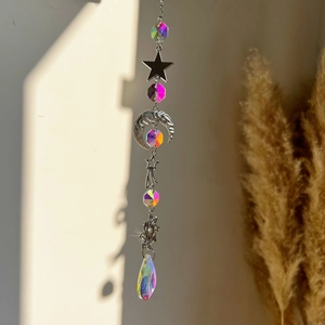 Detail of crystal sun catcher with moon and star metal accents reflecting rainbow light