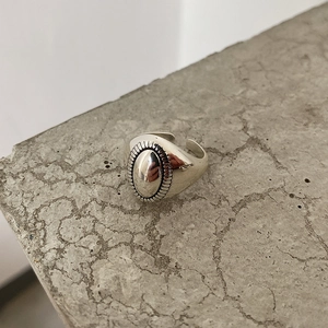 Close-up of vintage oval embossed 925 sterling silver ring on grey stone texture