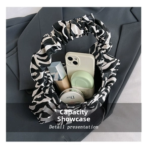 Detail presentation showing spacious zebra print pleated bag interior for essentials