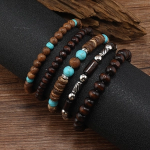 Detail of four-piece handmade bohemian wooden beaded bracelets on a rustic wooden stand