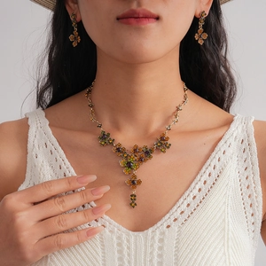 Vintage gold-toned necklace and earring set with colorful crystals worn by a model