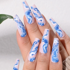 Close-up of long coffin press-on nails with blue and white marble pattern design
