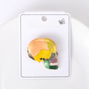 Detail of colorful enamel skull brooch on fashion jewelry card in minimalist tray