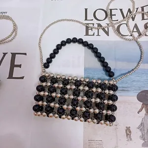 Detail of beaded handbag showing metal chain and capacity for a smartphone