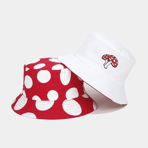 Detail of red polka dot and white reversible mushroom bucket hats in twill cotton fabric