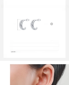 Macro detail of 925 sterling silver leaf earrings with woven texture and small crystals