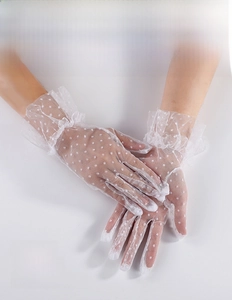 Detail of white mesh lace bridal gloves with polka dots and ruffled wrist cuffs