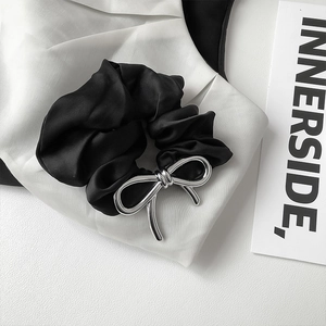 Minimalist black satin hair scrunchie with a silver metal bow pendant for women