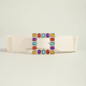 Detail of beige wide elastic belt with large square buckle featuring colorful gemstones