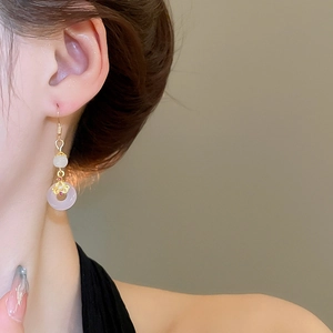 Gros plan de boucles d'oreilles style chinois avec pierre de jade et finition dorée