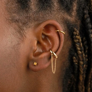 Vue macro d'un ensemble de bagues d'oreille dorées avec doubles chaînes et zircon jaune
