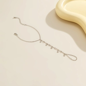 Detailed view of silver metal chain bracelet with delicate circular charm dangles