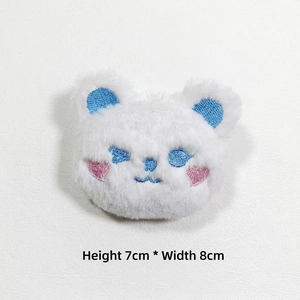 Detail view of plush white bear brooch with heart embroidery and 7x8cm dimensions
