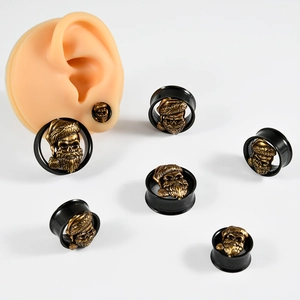 Black stainless steel ear gauges with golden skull in Santa hat shown on ear model