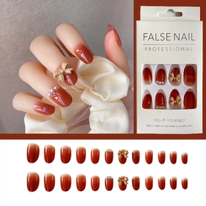 Gradient red-orange press-on nails set with 3D bows, pearls, and glossy finish