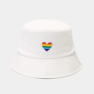 Detail of rainbow heart embroidery on a white cotton bucket hat with premium stitching
