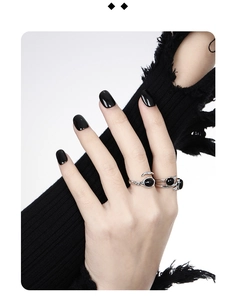 Detail of silver snake ring and black onyx stone on model with dark gothic nails