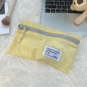 Detail view of yellow checkered waterproof travel organizer on soft plush surface