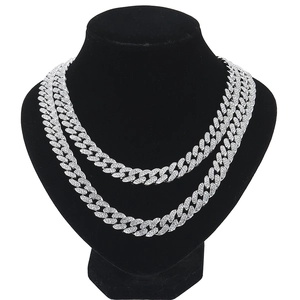 Close-up of two iced-out silver Cuban link necklaces displayed on a black neck bust