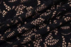 Gros plan du tissu en dentelle florale noire avec structure en maille et doublure lisse