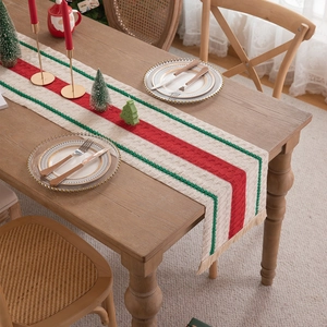 Christmas table runner with red and green stripes on a rustic wooden dining table