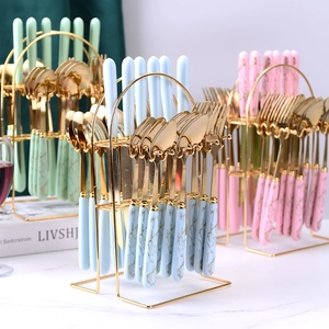 Gold stainless steel cutlery set with marble texture handles and golden storage rack