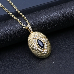 Detailed macro view of gold evil eye pendant with black stone and white zircon stones