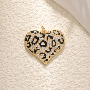 Leopard print black heart necklace pendant with sparkling cubic zirconia on cream surface