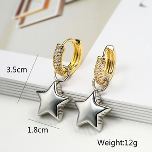 Detail view of asymmetric gold and silver star earrings showing dimensions and metal texture