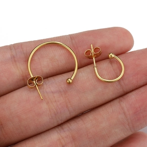 18k gold plated stainless steel C-shaped hoop earrings displayed on a hand