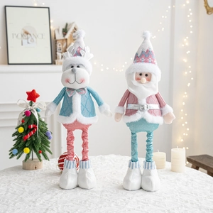 Detail view of plush Christmas reindeer and Santa dolls in soft pink and blue knit fabric