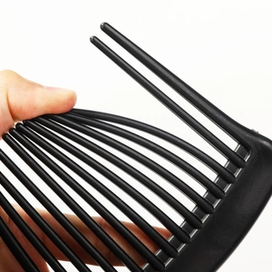 Flexible black wide-tooth hair comb being bent to show durability and material strength