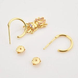 Détails macro des boucles d'oreilles insectes en argent S925 doré avec zircons colorés