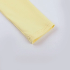 Detailed close-up of double-stitched cuff on light yellow long sleeve t-shirt