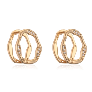 Minimalist gold geometric earrings with irregular wave design and inlaid zircons on white background