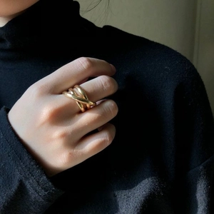 Modern interlocking triple-band ring in polished gold finish worn by a model