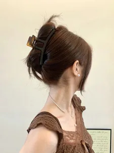 Detail view of large tortoise shell and black hair claw clip on an elegant hairstyle