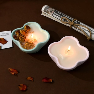 Floral clover shaped scented candle with dried flowers and warm ambient lighting