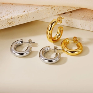 Boucles d'oreilles créoles épaisses polies en titane or et argent sur décor en pierre