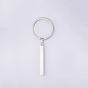 Close-up of a silver stainless steel rectangular bar pendant on a flat metal keyring