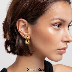 Polished gold-plated teardrop earrings and ear cuff set in small size on a model