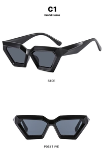 Close-up of black geometric sunglasses with sharp triangular frames and gray lenses