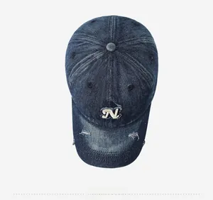 Macro view of distressed denim baseball cap with vintage frayed edges and white 'N' embroidery