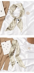 Macro detail of silk feel scarf featuring vintage map print and capital letter M